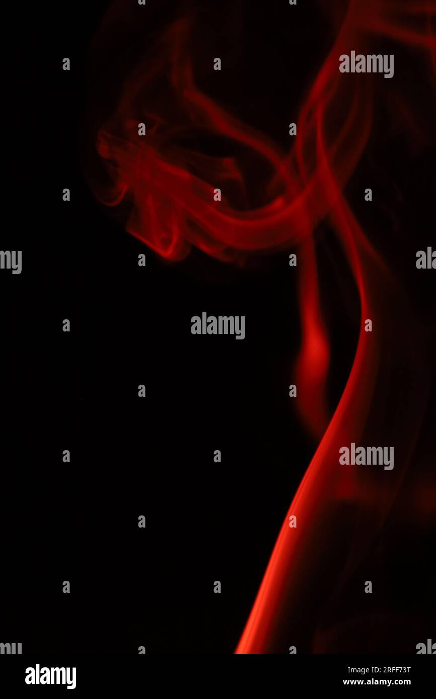 Roter Rauch auf dunklem Hintergrund, Muster, abstrakte Roter Nebel, vertikale Fotografie Stockfoto