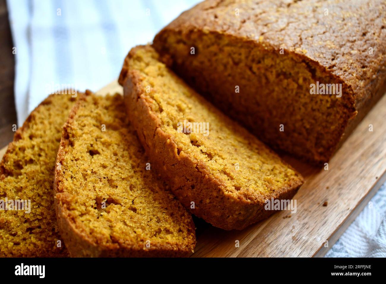 Horizontale Ansicht eines frisch gebackenen Kürbisbrotlaibs auf einem Holzschneidebrett Stockfoto