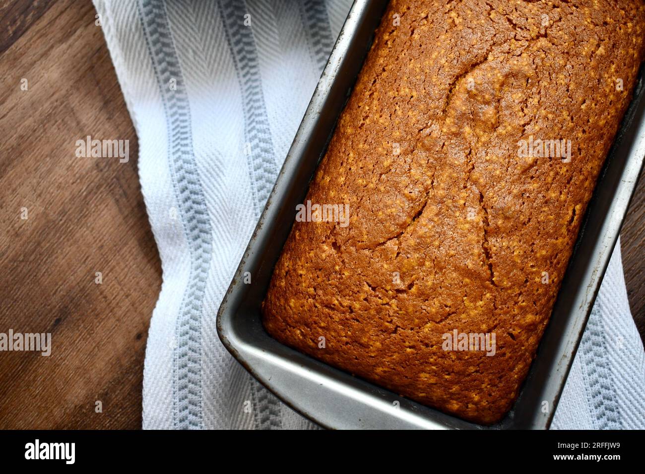 Frisch gebackener Laib mit gewürztem Kürbisbrot auf rustikalem Hintergrund Stockfoto