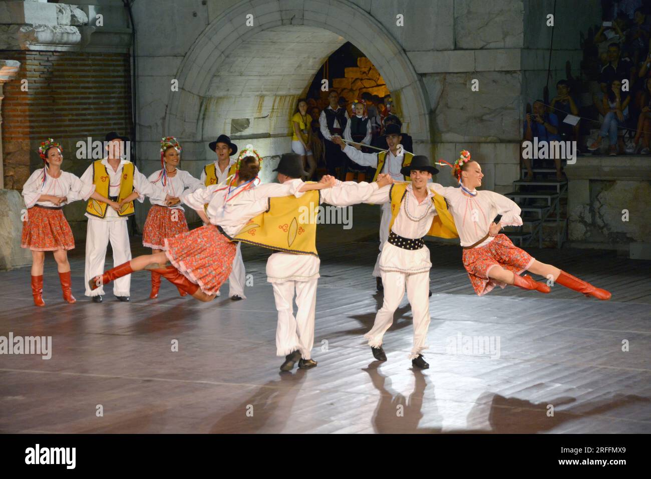Eine Gruppe von Tänzern aus der Republik Serbien in bunten Kostümen führt beim XXI International Folklore Festival in den anci einen traditionellen Tanz auf Stockfoto
