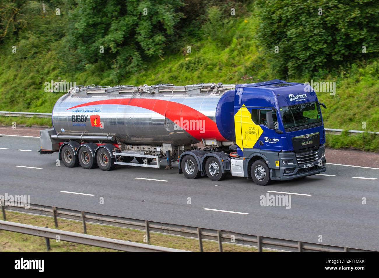 Mitarbeiter Von Bibby Distribution Tanker Fahrer. Transport von flüssiger Schokolade, Menzies Distribution; Blue MAN 26,510 6x2/2 BLS XX 12419cc Diesel HGV Tractor Unit Antriebsstrang; Fahrt auf der Autobahn M6 im Großraum Manchester, Großbritannien Stockfoto