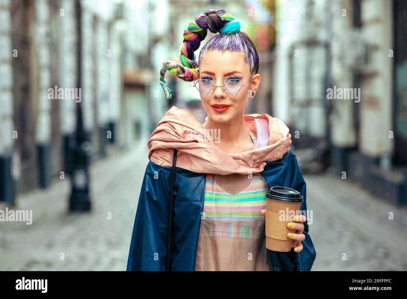 Cooles, flippiges junges Mädchen mit Piercings und verrücktem Haar genießt Kaffee zum Mitnehmen auf der Straße – Hipster Woman mit trendy bunten Avantgarde-Look, die Spaß hat Stockfoto