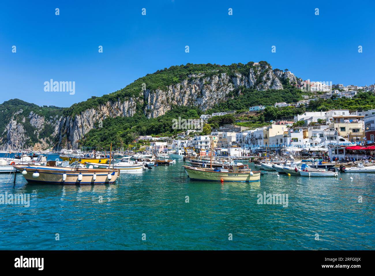 Boote liegen in Marina Grande mit den majestätischen Kalksteinklippen dahinter auf der Insel Capri im Golf von Neapel in der Region Kampanien in Italien vor Stockfoto