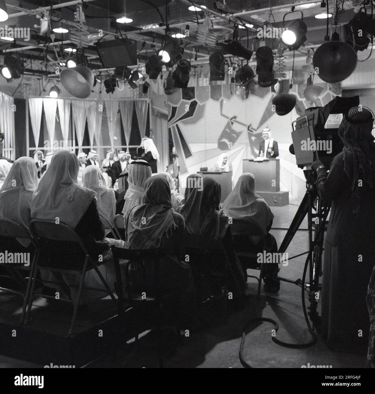 1960er Jahre, historisch, ein Publikum arabischer Männer mit traditionellen Kopfbedeckungen, die in einem saudischen Fernsehstudio bei einer Ausstrahlung einer Fernsehsendung in Dschidda, Saudi-Arabien, sitzen. Stockfoto