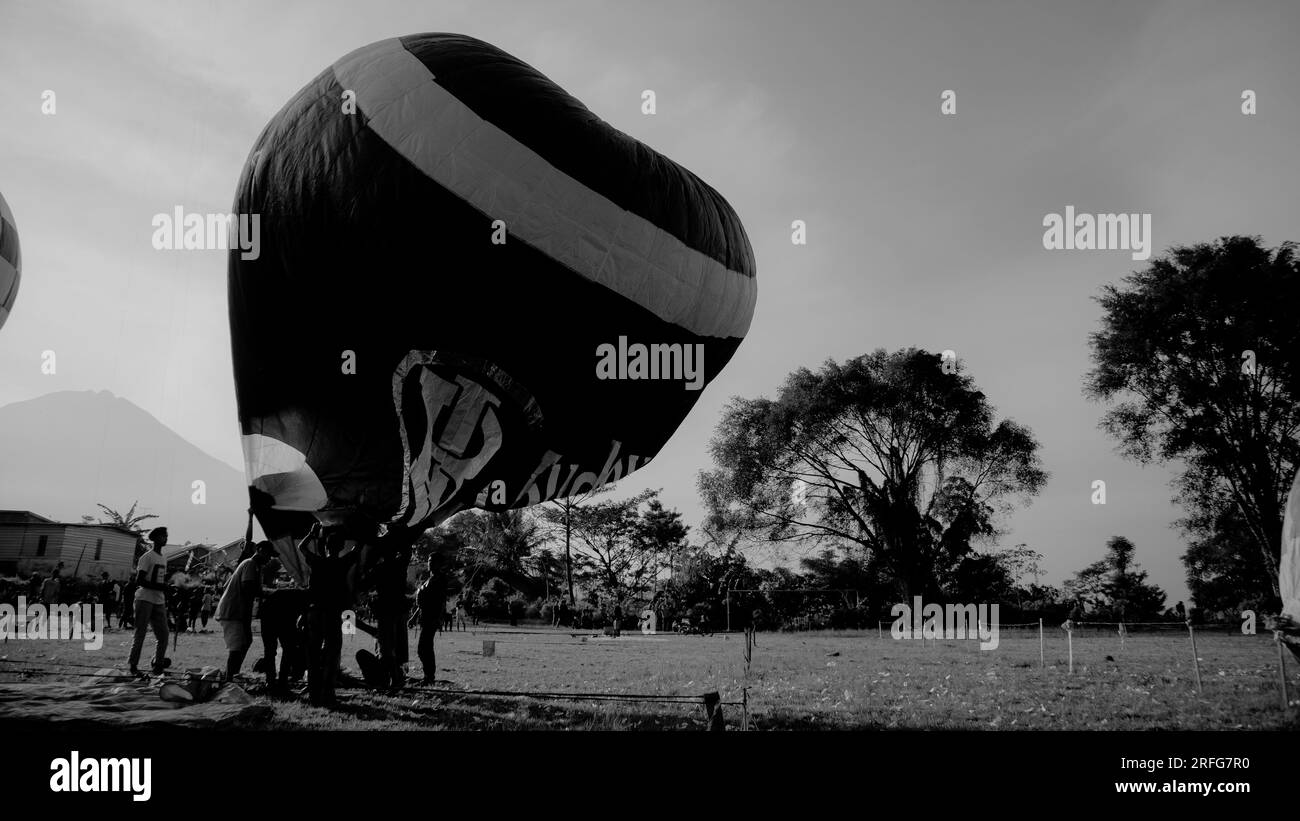 Teilnehmer des Wonosobo Air Balloon Festival 2022 versuchen, einen Ballon zu fliegen, indem sie die Luft im Ballon erwärmen. Stockfoto