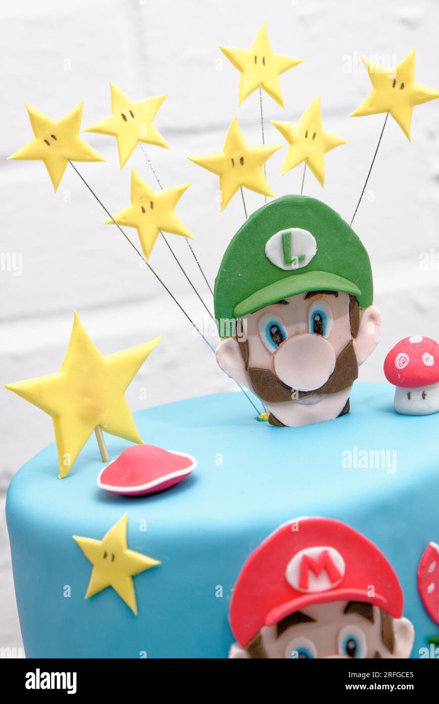 Super Mario Bros Geburtstagsparty Kuchen - Pastelblauer Geburtstagskuchen. Festlicher Kuchen mit blauem Marzipan Stockfoto
