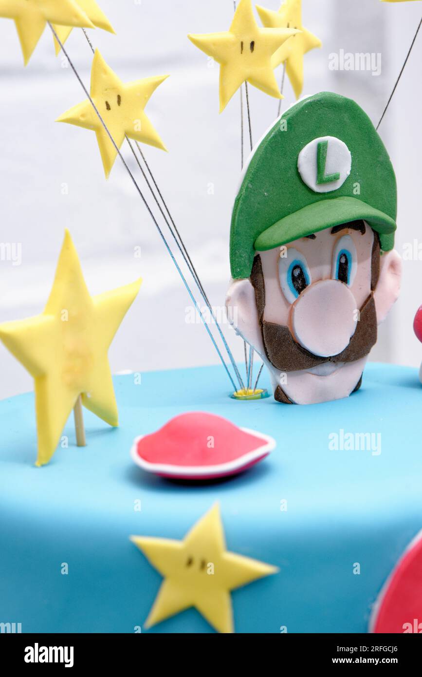 Super Mario Bros Geburtstagsparty Kuchen - Pastelblauer Geburtstagskuchen. Festlicher Kuchen mit blauem Marzipan Stockfoto