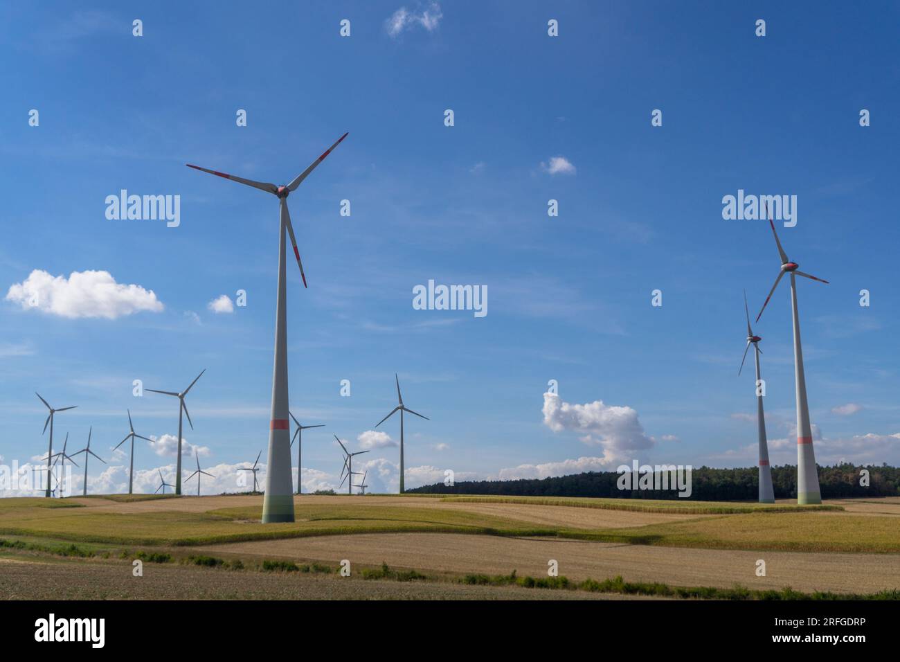 Blick auf viele Windmühlen zur Stromerzeugung im Sommer in der Nähe der deutschen Stadt Neustadt Hessen, Stockfoto