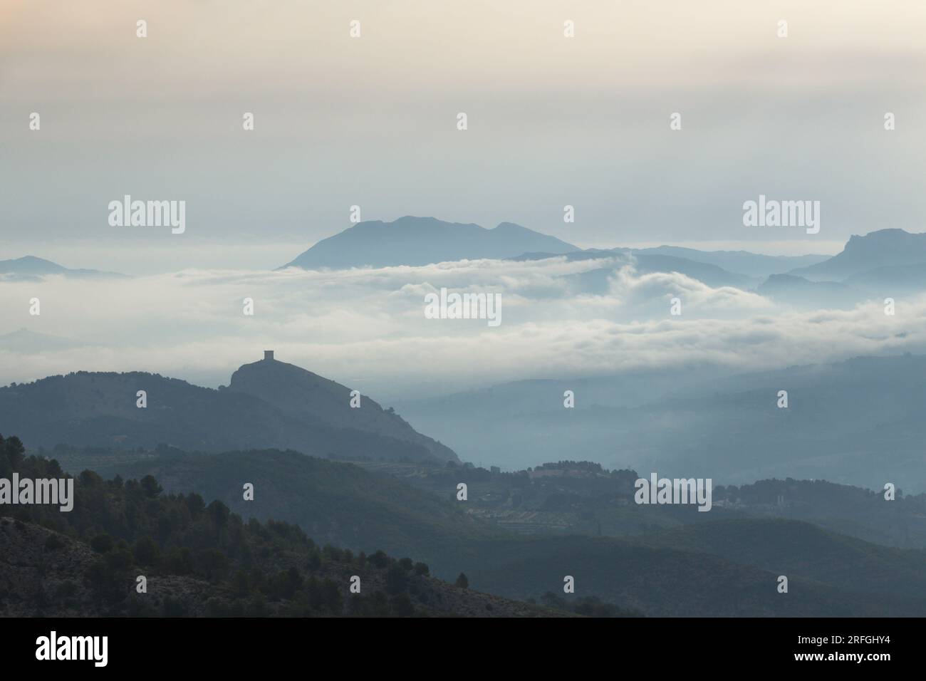Nebelmeer im Tal und Schloss Cocentaina mit La Serrella im Hintergrund, Spanien Stockfoto