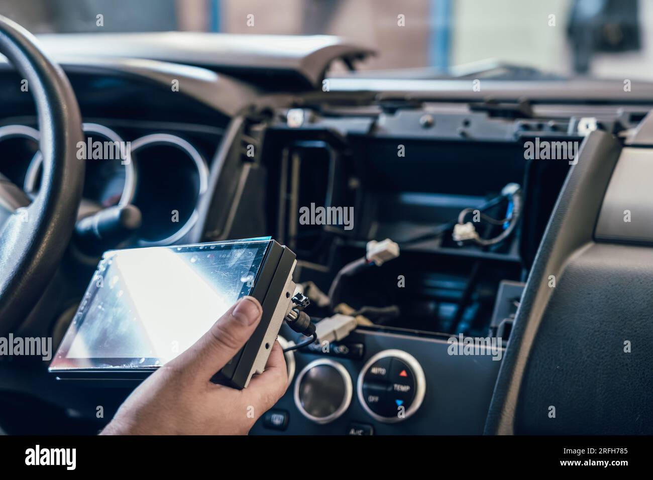 Ein Autoelektriker oder Autowerkstatt installiert ein Multimedia