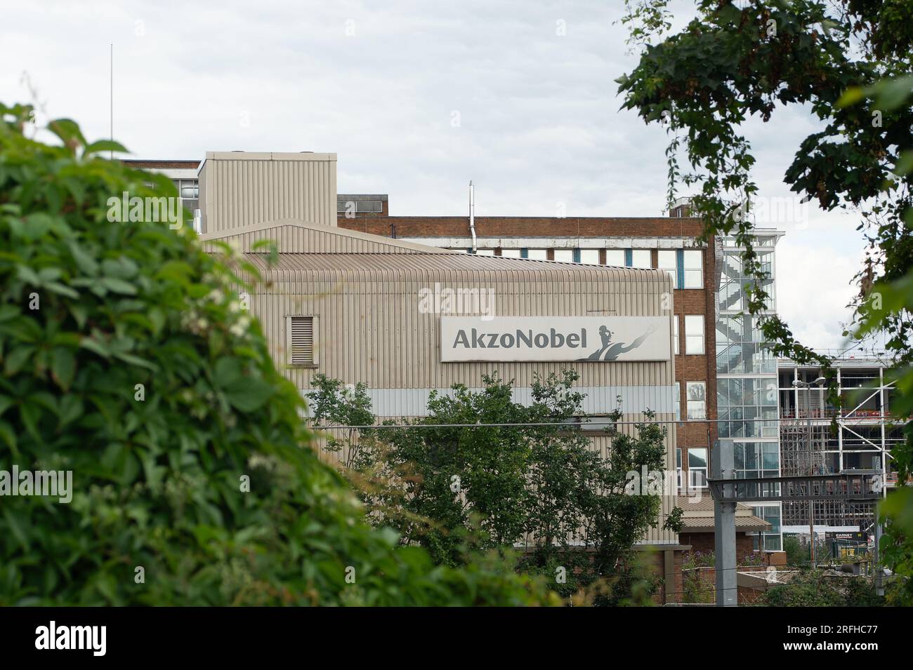 Slough, Berkshire, Großbritannien. 3. August 2023. Nach dem Verkauf der ehemaligen Akzo Nobel Produktionsstätte für Dekorationsfarbe in Wexham Road, Slough, wurde eine Planungsanwendung für ermöglichende Arbeiten der American Data Centre Company, Equinix, Inc. Dem Slough Borough Council vorgelegt. Die Anwendung „Enabling Works“ umfasst den Abriss der verbleibenden Gebäude auf dem Gelände, einschließlich der ehemaligen Akzo Nobel Forschungs- und Entwicklungsgebäude (siehe Abbildung). Vor kurzem wurde eine lange Reihe reifer hoher Nadelbäume auf dem Gelände gefällt, die parallel zur Wexham Road verlaufen. Die Holzspäne stapeln sich auf Stockfoto