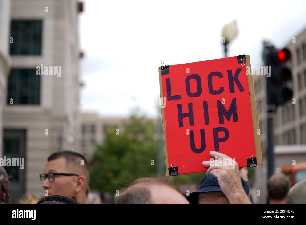 Washington, Usa. 03. Aug. 2023. Ein Demonstrant hält ein Poster mit dem Titel "sperrt ihn ein", während der ehemalige Präsident Donald Trump am Donnerstag, den 3. August 2023, in Washington DC zu seiner Anklageerhebung wegen Wahlunterwanderung eintrifft. Sonderanwalt Jack Smith hat den ehemaligen Präsidenten wegen vier Anschuldigungen in Verbindung mit seinen Handlungen vor und nach dem Angriff auf das US-Kapitol vom 6. Januar angeklagt. Foto: Bonnie Cash/UPI Credit: UPI/Alamy Live News Stockfoto