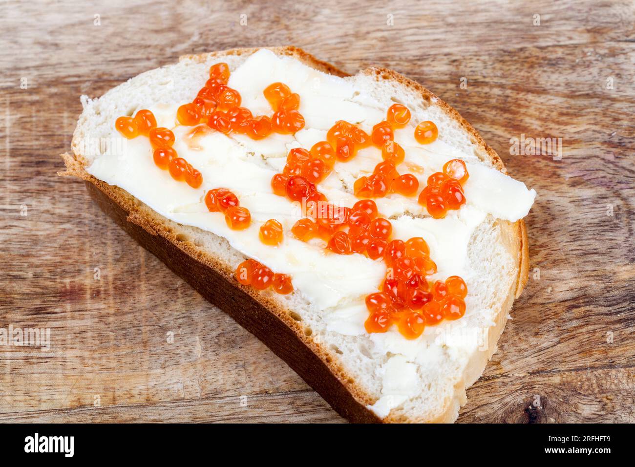Ein Stück Weizenbrot mit Butter und rotem Kaviar, Lachs-roter Kaviar auf Brotzubereitung von Snacks Stockfoto