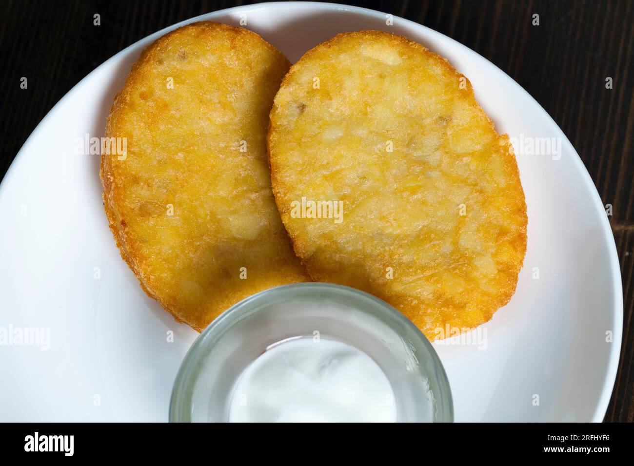 Kartoffelpfannkuchen mit saurer Sahne auf einem Teller, ein ...