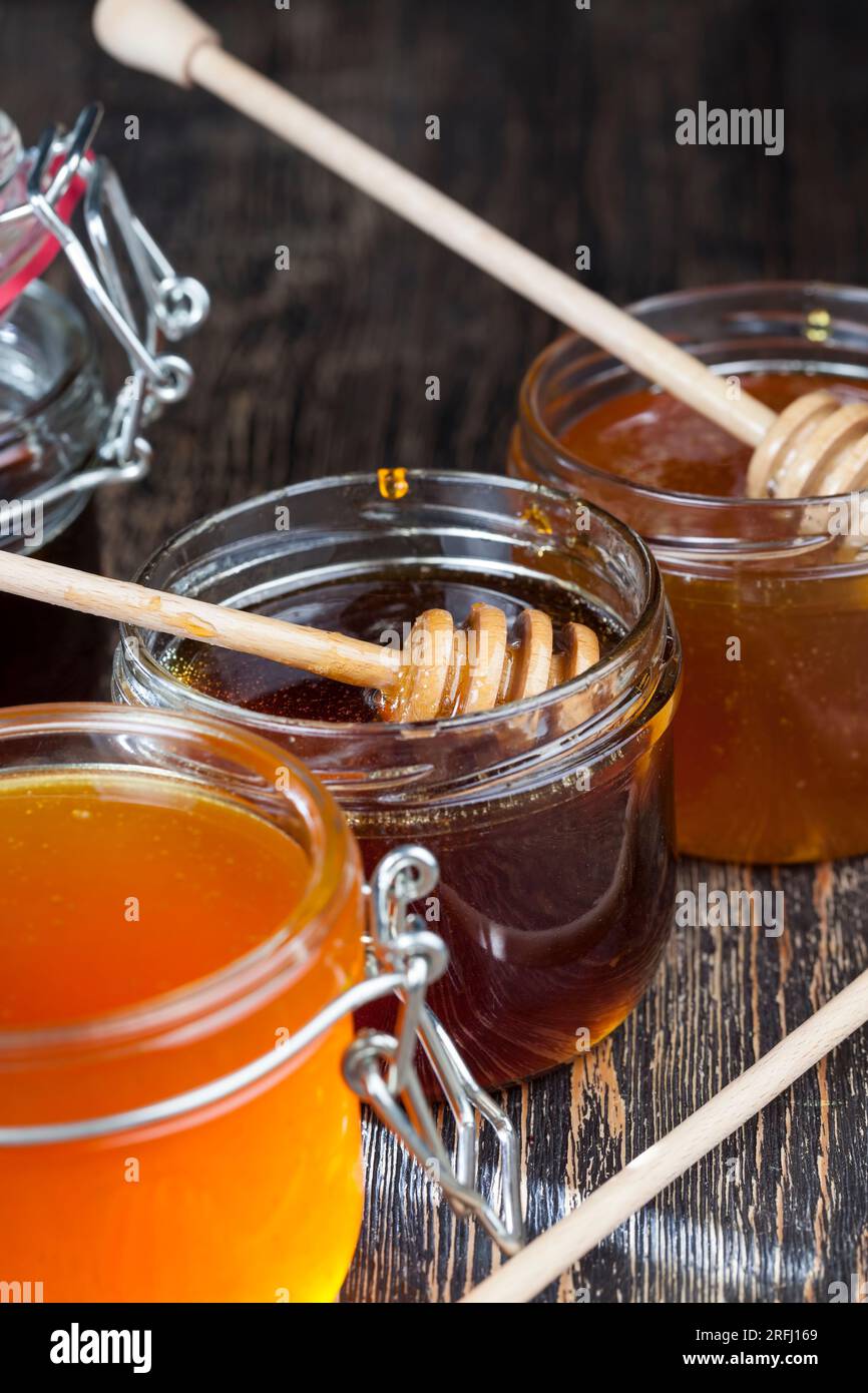 In Honig getaucht, speziell aus hausgemachtem groben Holzlöffel, süßem Bienenhonig und Holzlöffel, mit dem Sie Honig umfüllen und eingießen können, ohne dass Stockfoto