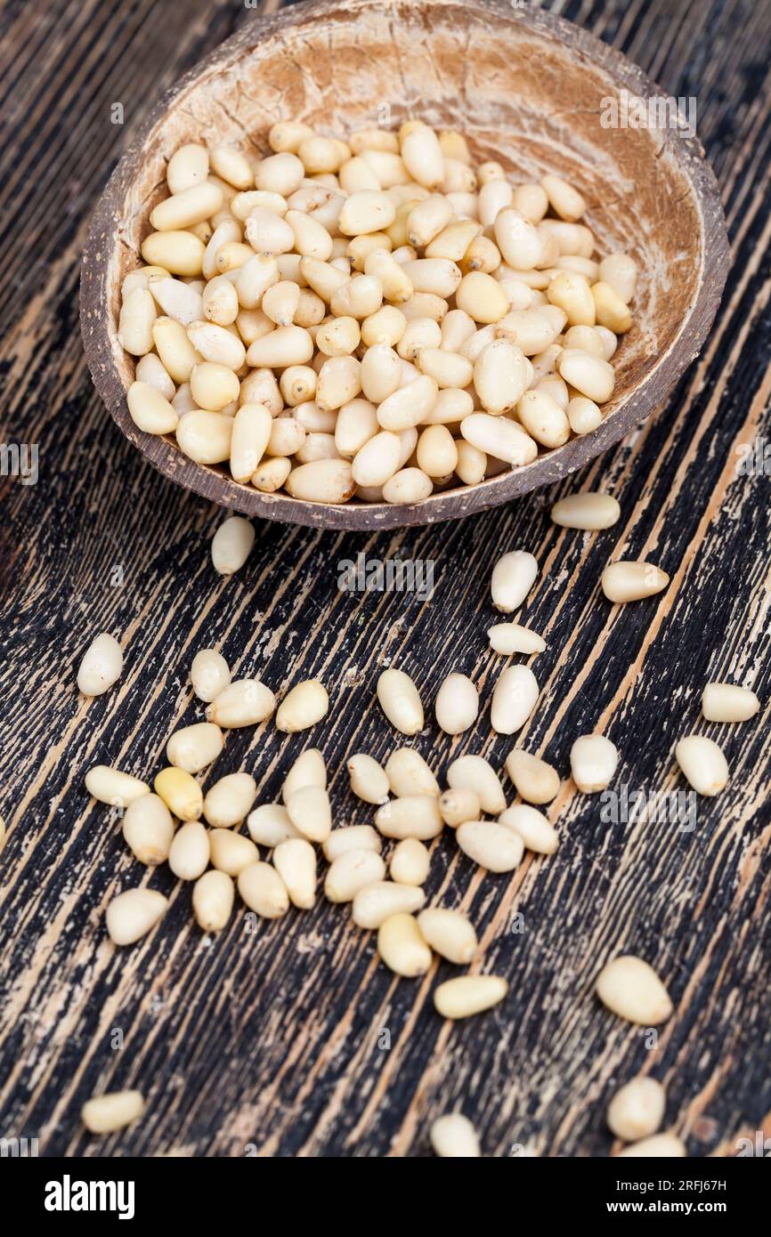 Nützliche Nüsse, ein Teil der Schale bleibt auf den Zedernüssen, geschälte Pinienkerne kleiner Größe Stockfoto