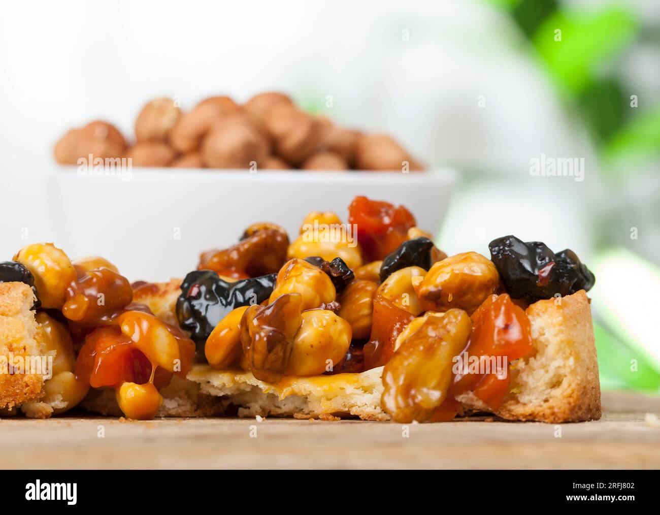 Weizentörtchen mit Nüssen und getrockneten Früchten in Sahne-Karamell, Weizentörtchen mit süßer Füllung, knusprige Törtchen mit Haselnüssen, Erdnüssen und anderen in Stockfoto