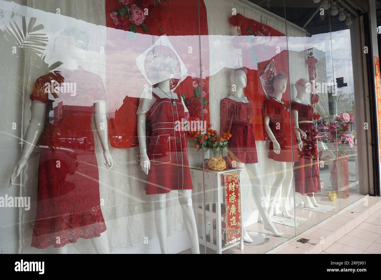 Schaufensterpuppen im Schaufenster in roten Kleidern während des chinesischen Neujahrsverkaufs in Malaysia Stockfoto