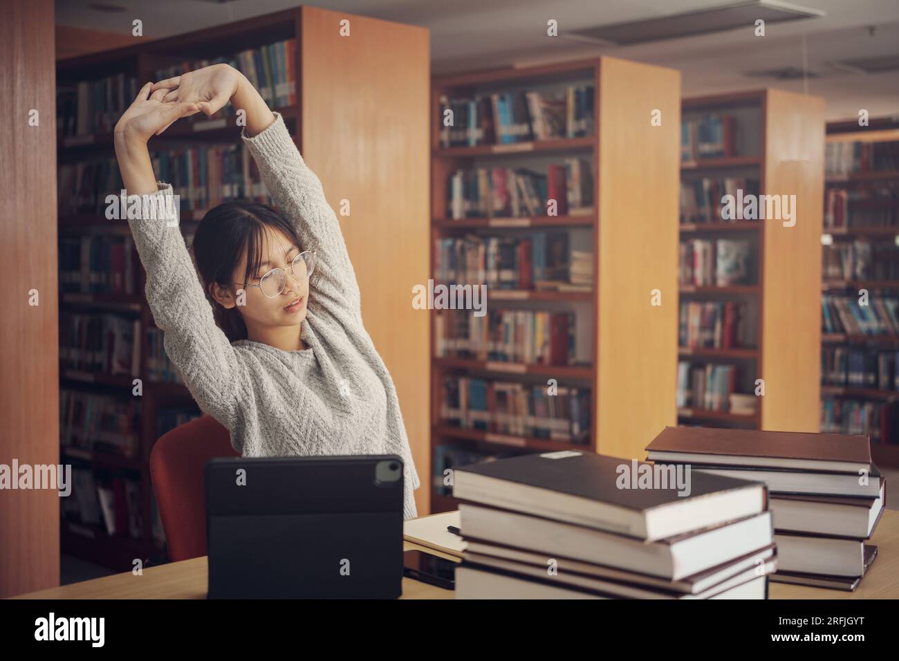 Schülerinnen, die lesen und arbeiten, dehnen sich in der Bibliothek der Universität oder des Colleges. Stockfoto