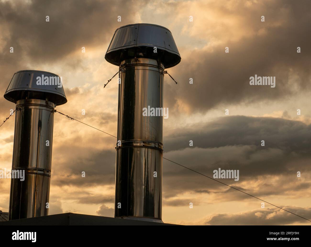Industrielle Chromrohre über Sonnenuntergang Wolkenhintergrund Stockfoto