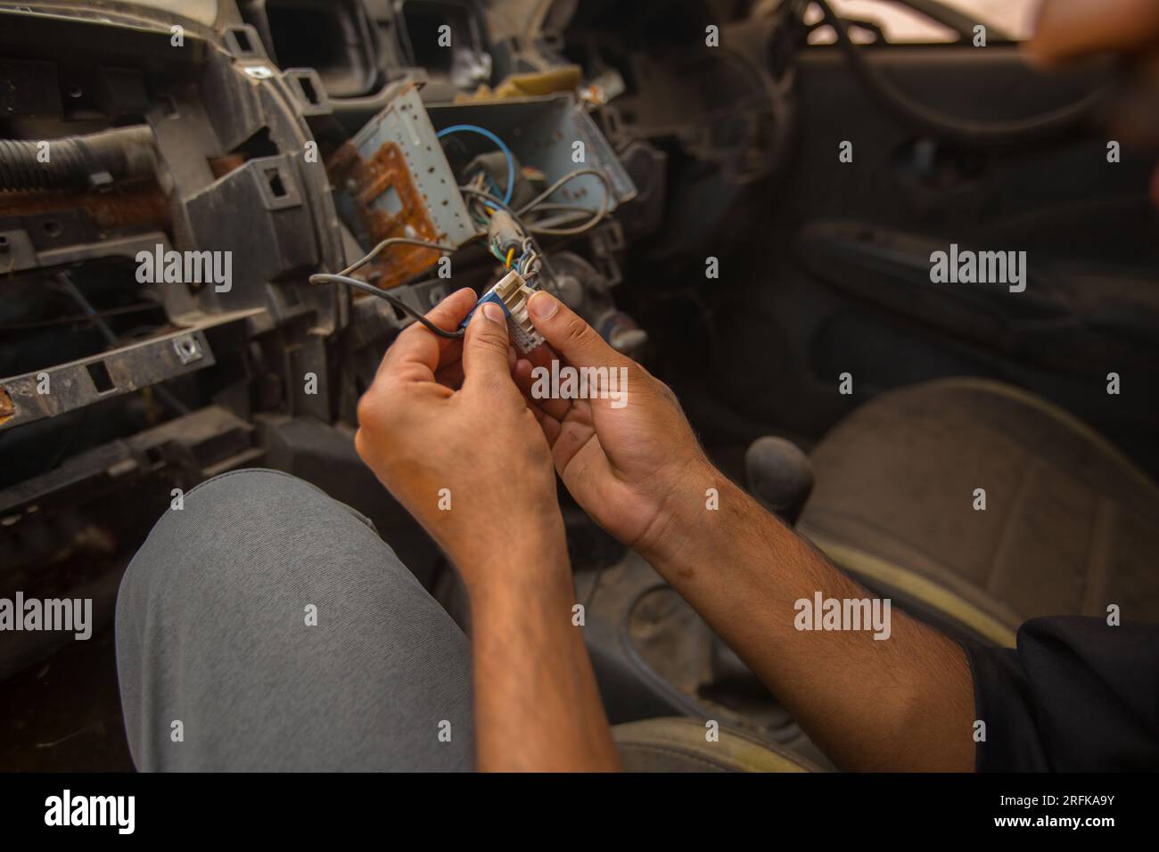 Nahaufnahme eines Mechanikers, der ein elektrisches Gerät eines Autos repariert Stockfoto