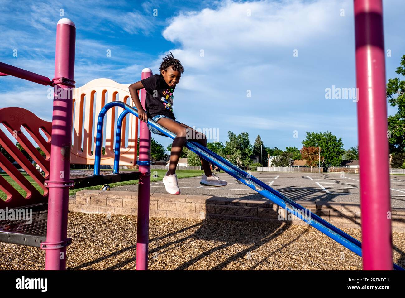 Junge Afroamerikanerin, die auf dem Spielplatz spielt Stockfoto