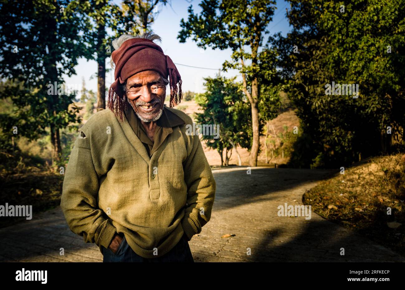 Oktober 14. 2022 Uttarakhand, Indien. Glücklicher indischer Landsmann, gekleidet in einheimischer Kleidung, lächelnd in einer malerischen ländlichen Umgebung. Den Geist verkörpern Stockfoto