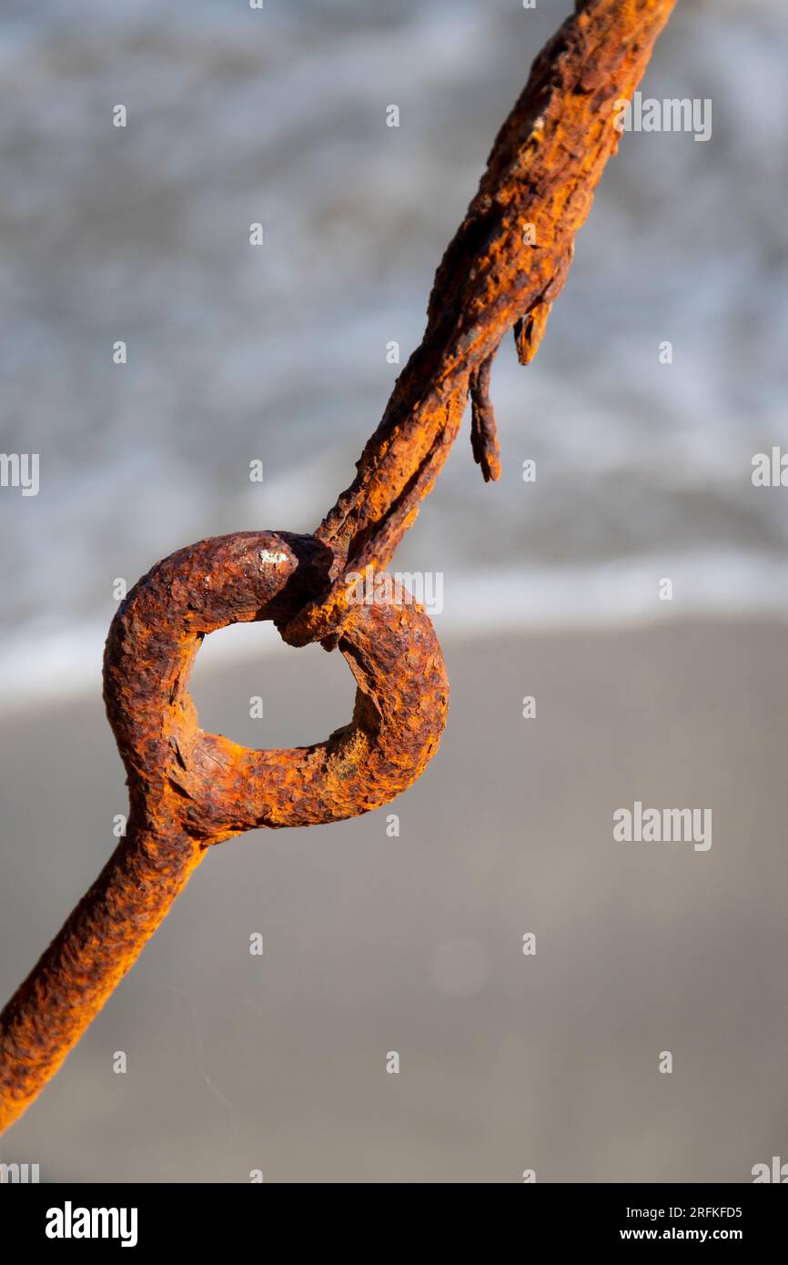 Rostiger Stahlring und Kabel neben dem Strand in Plimmerton, Porirua, Wellington, North Island, Neuseeland Stockfoto