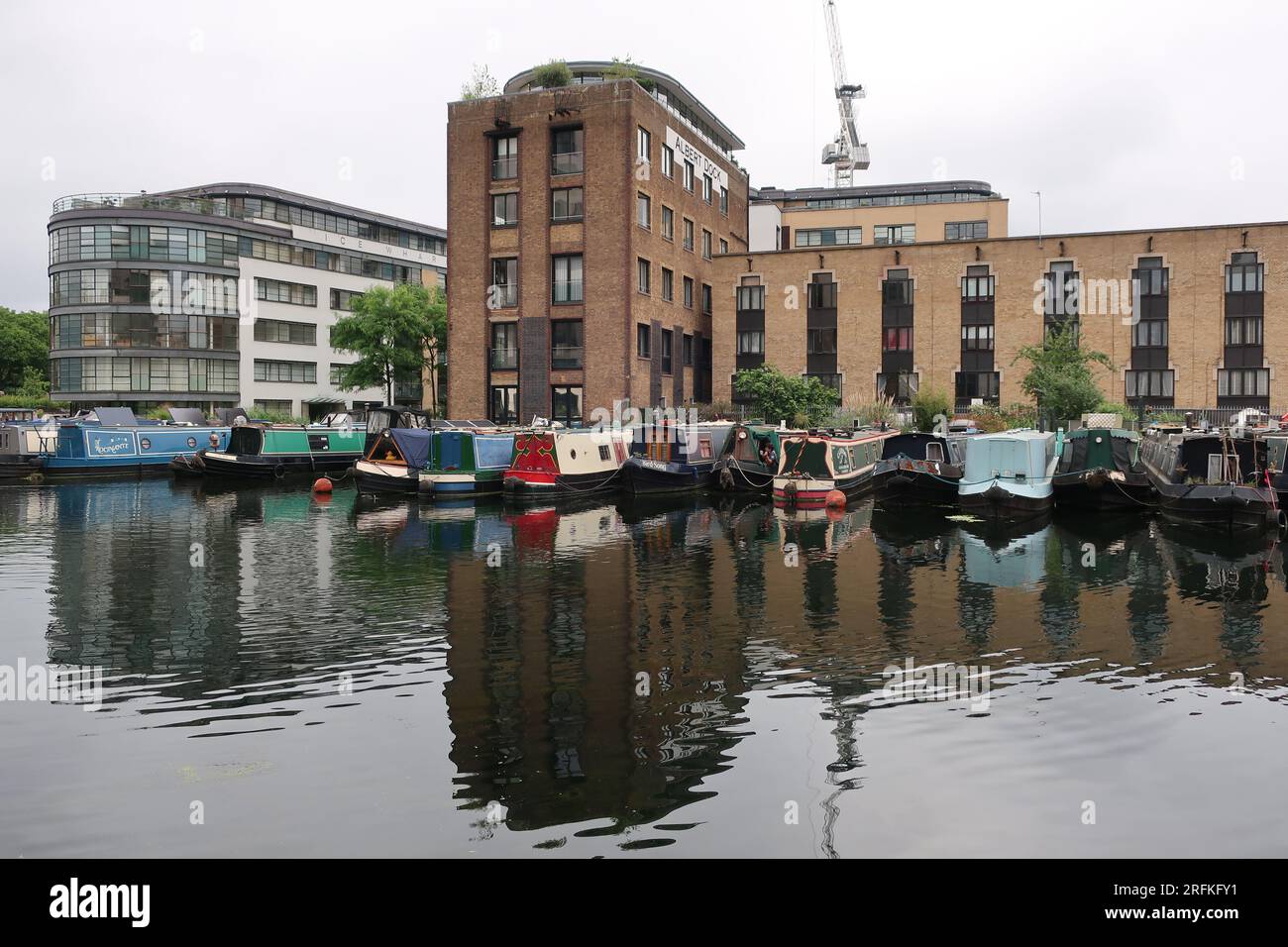 Leben auf dem Wasser: Schmalboote, die am Battlebridge Basin am Regent's Canal neben Londoner Wohnungen und dem ehemaligen Albert Dock ankerten. Stockfoto