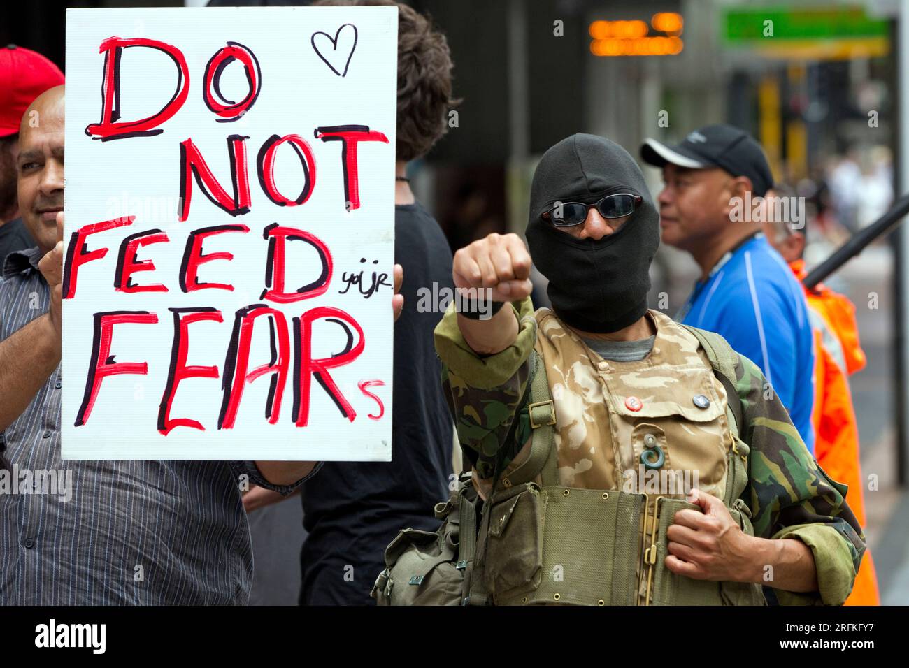 Ein in Khaki-Uniform gekleideter Demonstrante hält mit seiner Faust ein Banner, gefolgt von anderen Demonstranten. Stockfoto