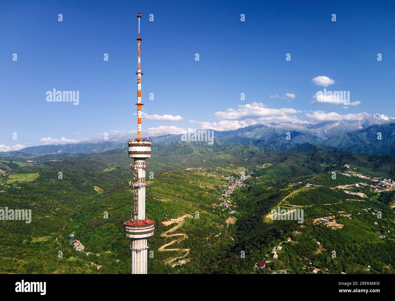 Luftaufnahme der Drohne des Hochfernsehturms von Symbol Almaty City und Park auf dem Koktobe-Hügel vor den Schneebirgen in Kasachstan Stockfoto