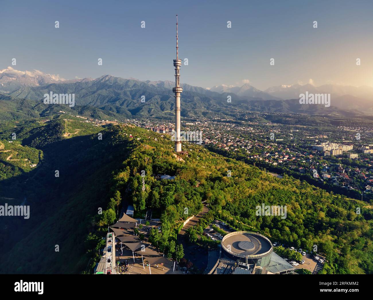 Luftaufnahme der Drohne des Hochfernsehturms von Symbol Almaty City und Park auf dem Koktobe-Hügel vor den Schneebirgen in Kasachstan Stockfoto