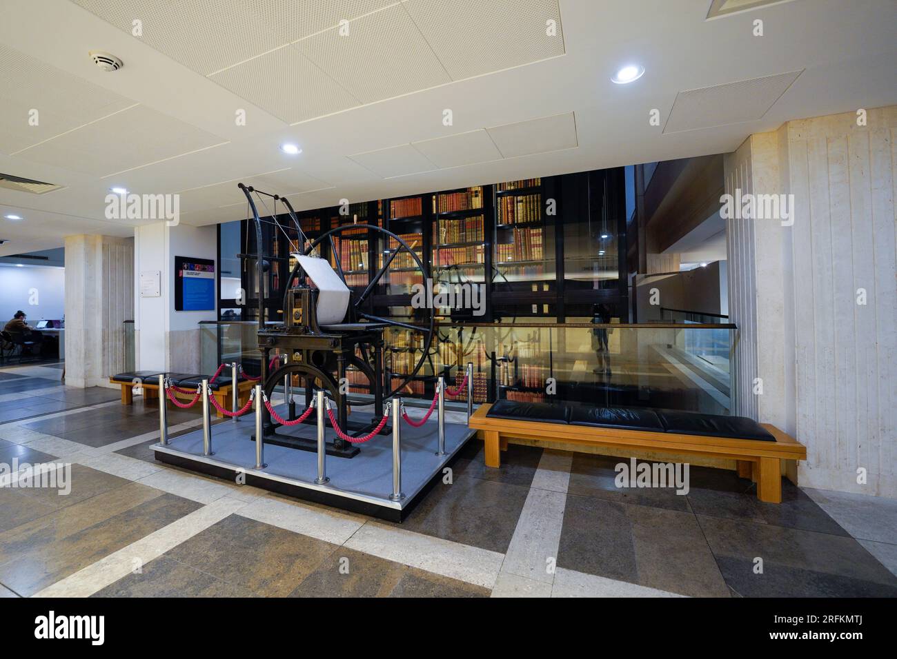 London, England, Großbritannien - 31. Juli 2022. Innenraum der British Library mit einer alten, antiken Druckmaschine, ausgestellten Druckgeräten, Bücherregalen Stockfoto