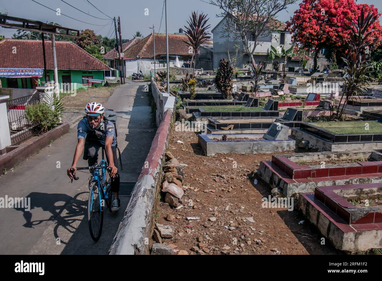 Bogor, Indonesien - 01. August 2023: Radfahrer wandern durch einen Friedhof in Bogor, West-Java. Stockfoto