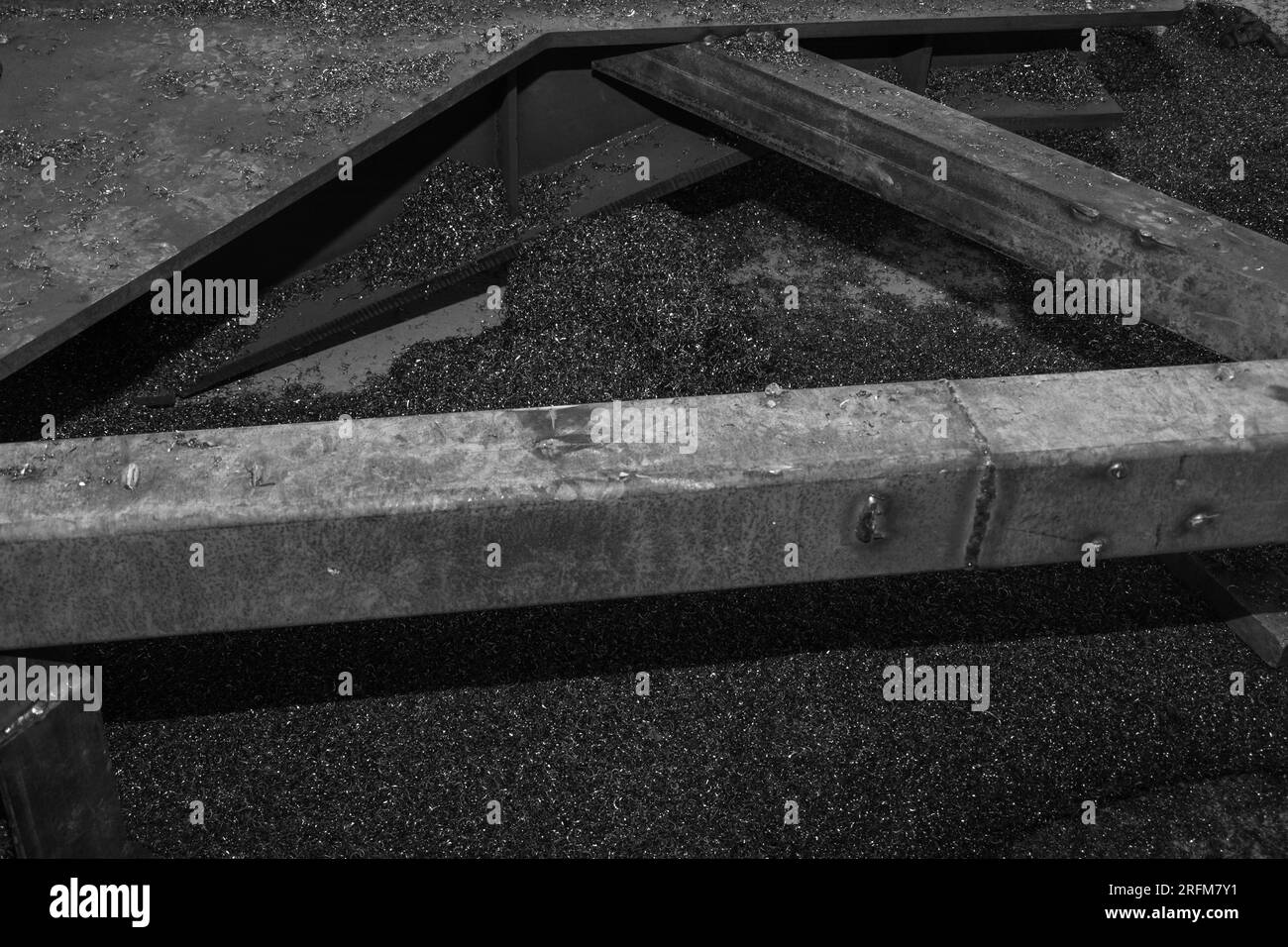 Metallteil und Metallspäne. Viele Metallspäne nach der Arbeit an einer Fräsmaschine oder CNC-Maschine. Struktur von Metallspänen. Aluminium-Rasierbügel Stockfoto