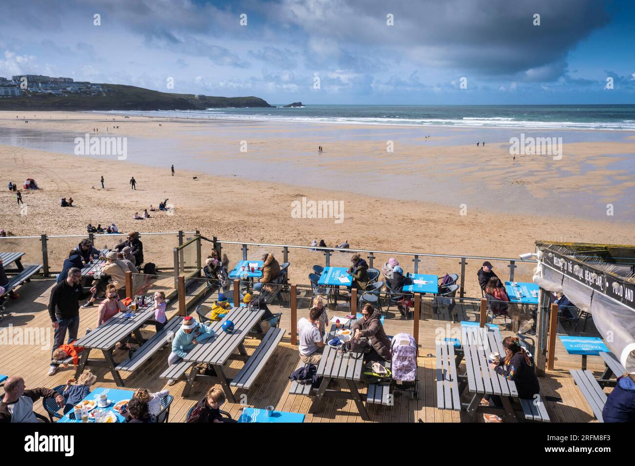 Urlauber entspannen sich auf der Terrasse der Fistral Beach Bar in Newquay in Cornwall, England, Großbritannien. Stockfoto