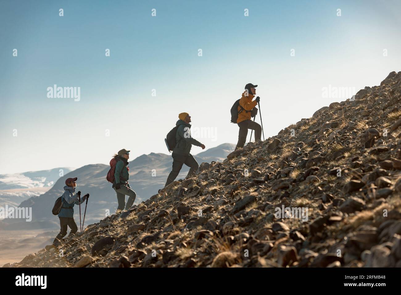 Eine Gruppe junger Wanderer geht gemeinsam mit Rucksäcken bergauf. Konzept des aktiven Tourismus Stockfoto