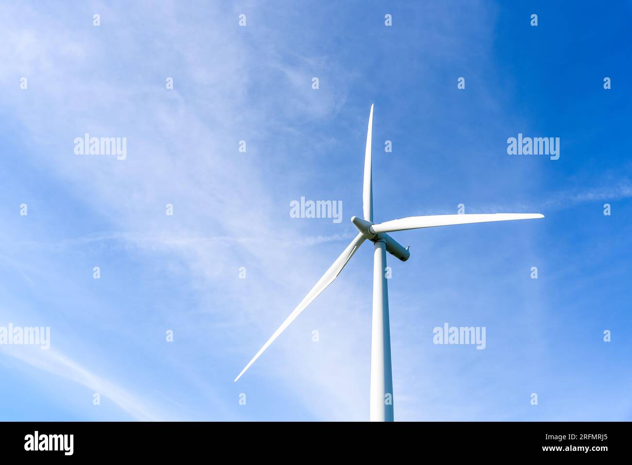 Detail einer Windturbine mit blauem Himmel und Wolken an einem sonnigen Herbsttag Stockfoto