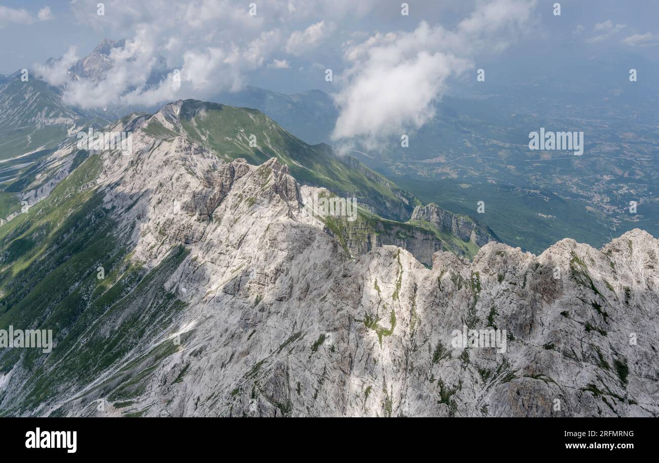 Luftlandschaft aus einem Segelflugzeug, mit Meeresbrise, Wolken und steilen Klippen am Laga Mountain Range, von Westen in hellem Sommerlicht bei Cala aufgenommen Stockfoto
