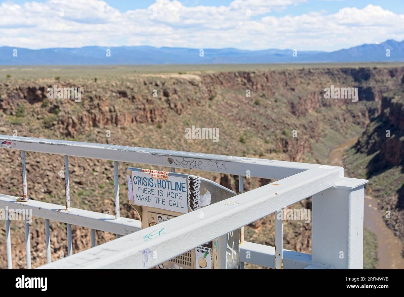 Crisis Hotline Call Box auf Geländer zur Rio Grande Gorge Bridge hoch über dem Rio Grande River auf US 64 mit Sangre de Cristo Mountains am Horizont Stockfoto