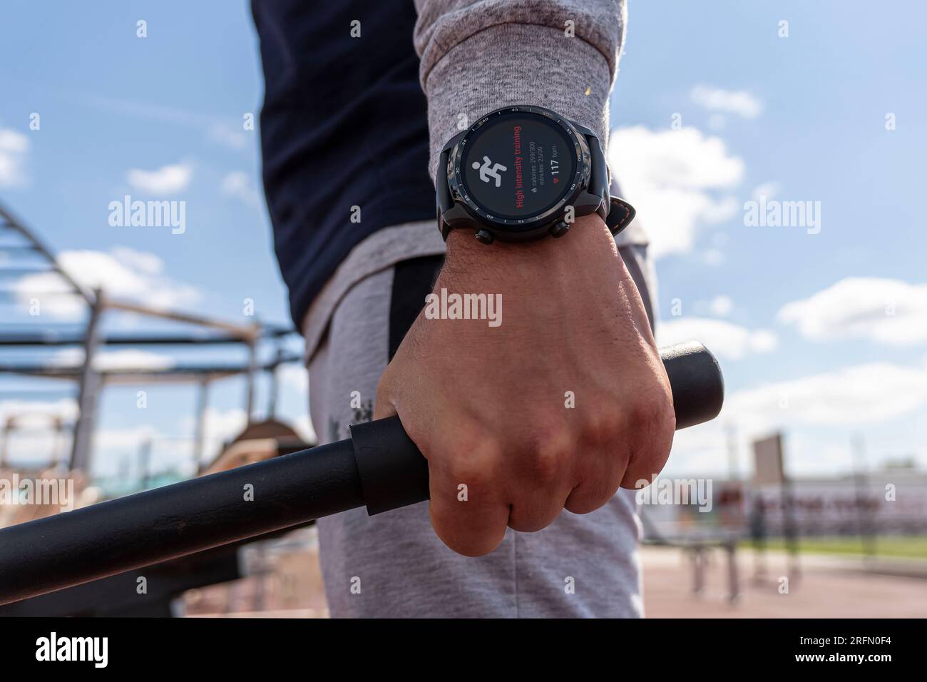Smartwatch am Körper tragbares Smart Tech Fitness aktiv Sportler Haupt verwendet Sportuhr beim Training Kardio-Workout seine Herzfrequenz prüfen. Stadtstadion. Stockfoto