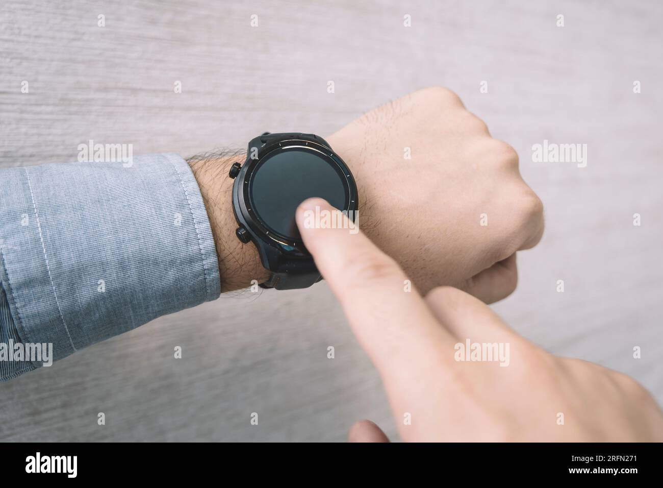 Fitnessuhr am mans-Unterarm mit Datum, Uhrzeit, Herzfrequenz und Schrittzähler. Stockfoto