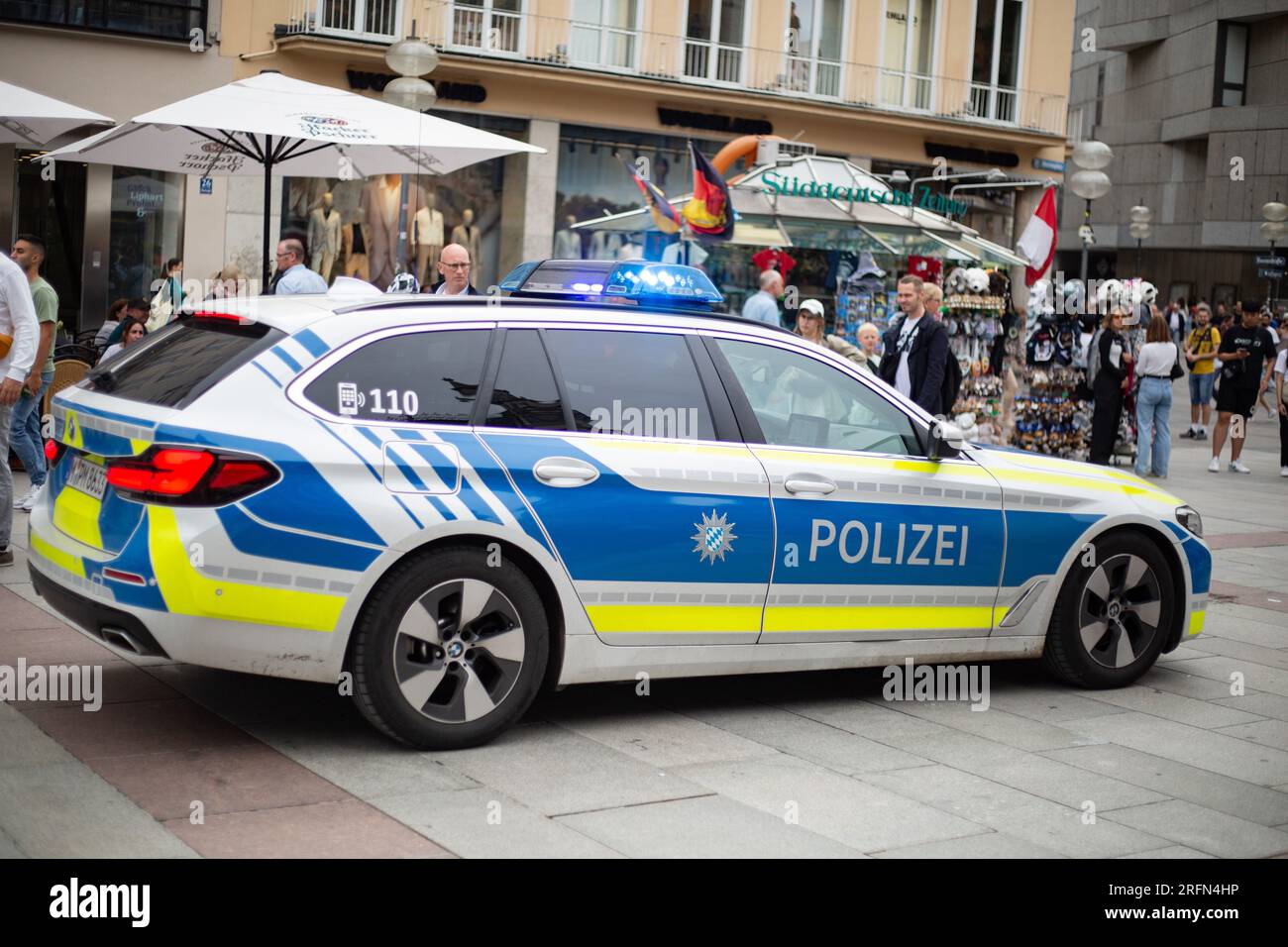 München, Deutschland. 04. Aug. 2023. Polizeiwagen fährt durch die Münchner Fußgängerzone mit blauen Lichtern, während ein Hubschrauber darüber fliegt. (Foto: Alexander Pohl/Sipa USA) Guthaben: SIPA USA/Alamy Live News Stockfoto