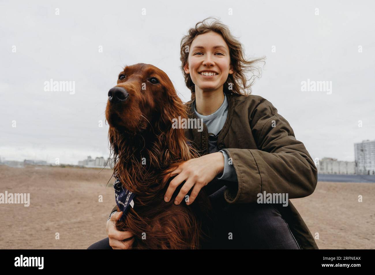 Porträt einer jungen, glücklichen Frau mit ihrem Hund. Irischer Setter-Hund und liebevolle, fröhliche Geliebte. Stockfoto