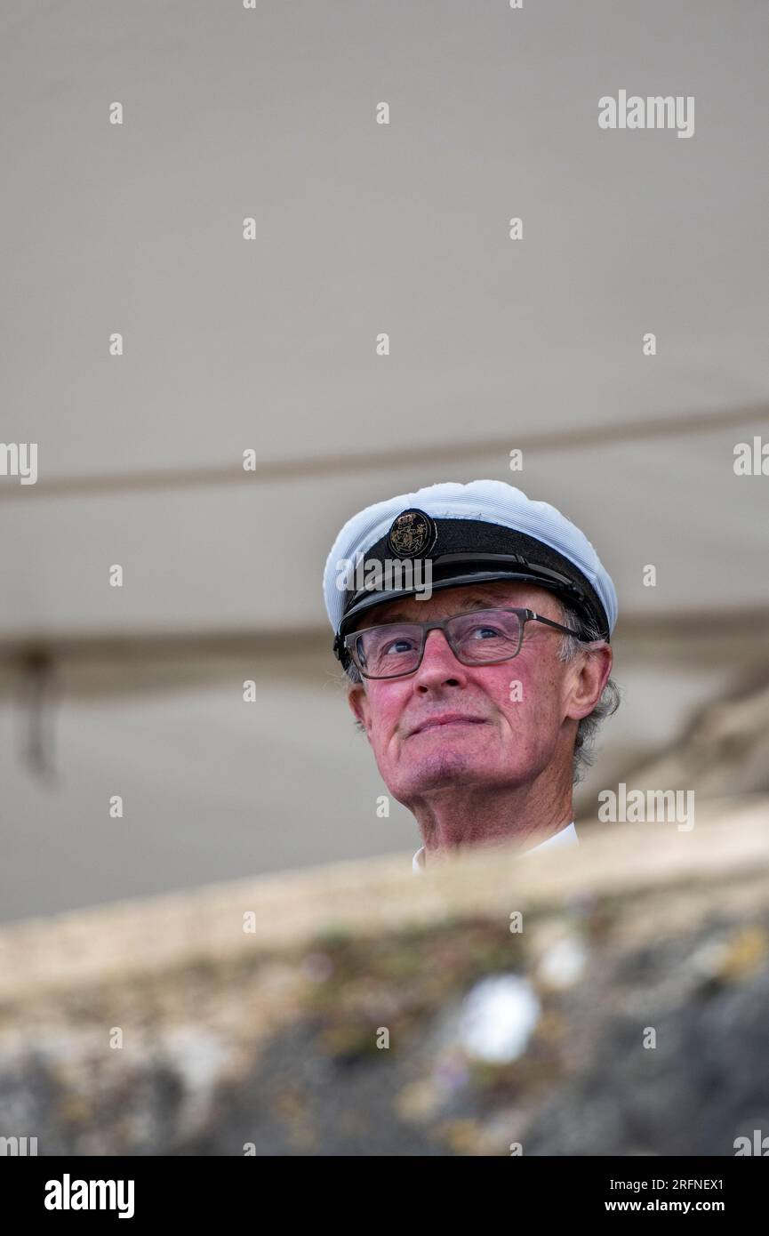 mitglied des königlichen Jachtgeschwaders in cowes, trägt einen Captains-Hut und blickt vom Balkon aus auf die Regatta während der cowes Week Stockfoto