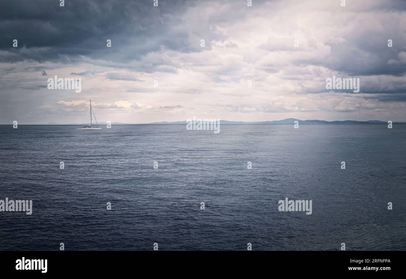 Panoramablick auf das Meer mit einem Segelboot am Horizont Stockfoto