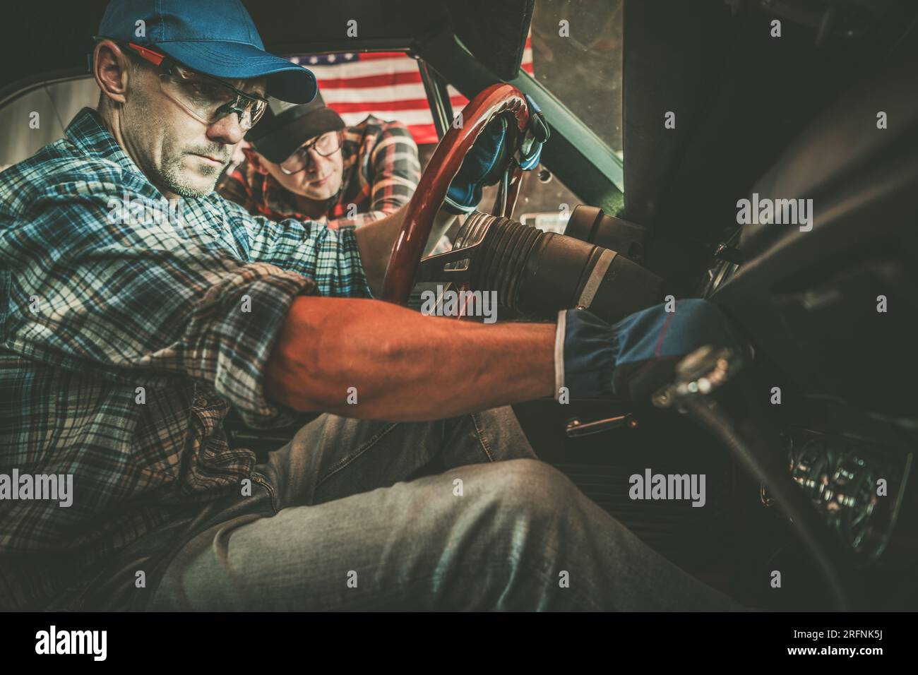 Der Besitzer eines amerikanischen Klassikers und sein professioneller Automechaniker, der Prüfungen durchführt Stockfoto