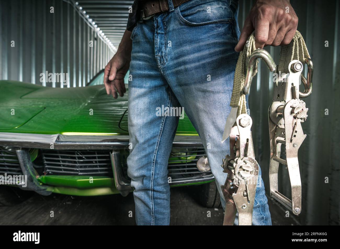 Ein weißer Mann mit Riemen neben dem versendeten Classic-Auto Stockfoto