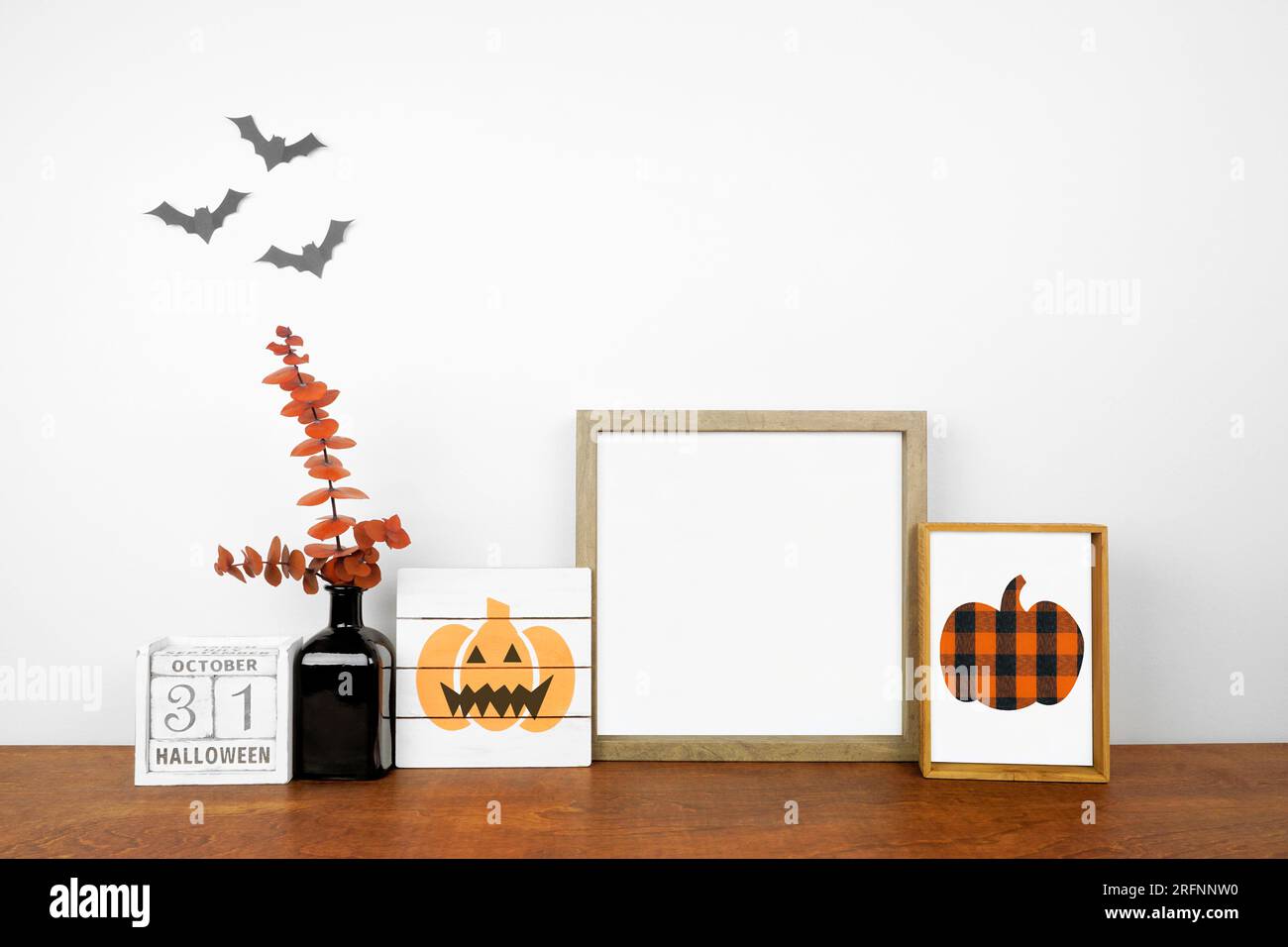 Halloween-Modell. Schäbige, schicke Holzschilder, Kalender und orangefarbene Zweige auf einem Holzregal an einer weißen Wand. Speicherplatz kopieren. Stockfoto