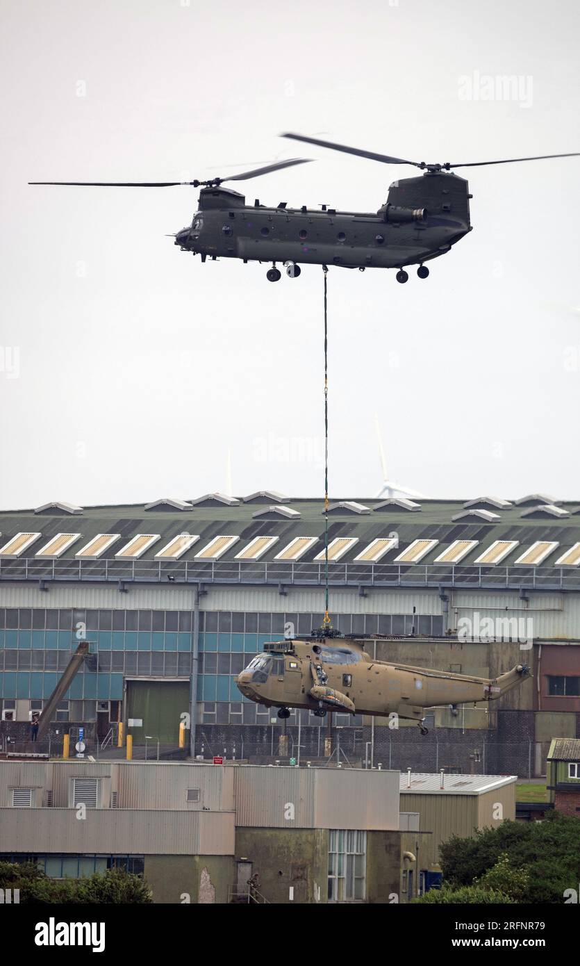 RAF Chinook vom 28. Geschwader RAF Benson Last hebt einen Ex Royal Navy Seaking Helicopter auf RAF St Mawgan Stockfoto